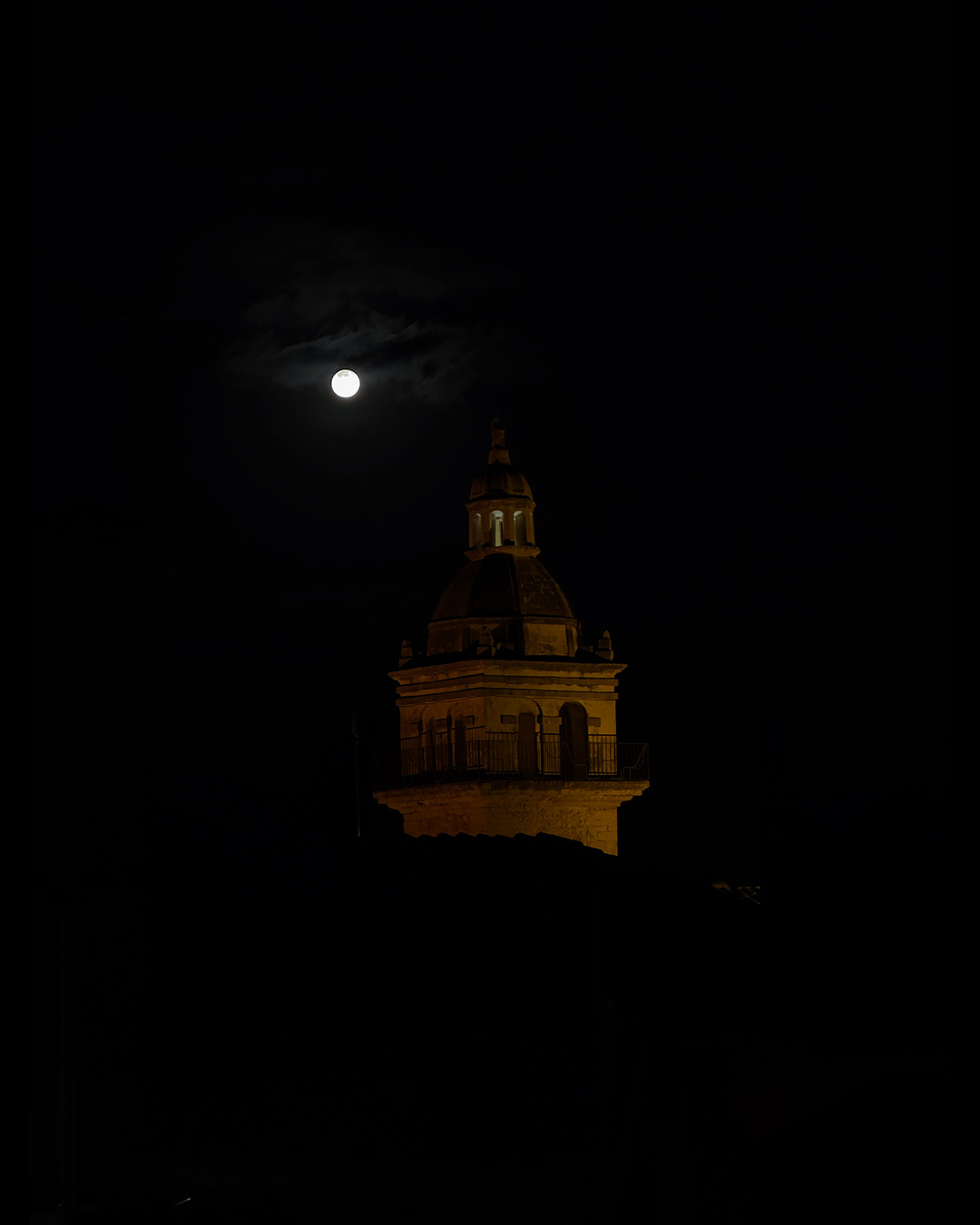 Fotografía original de una torre y la luna antes de la edición con inteligencia artificial